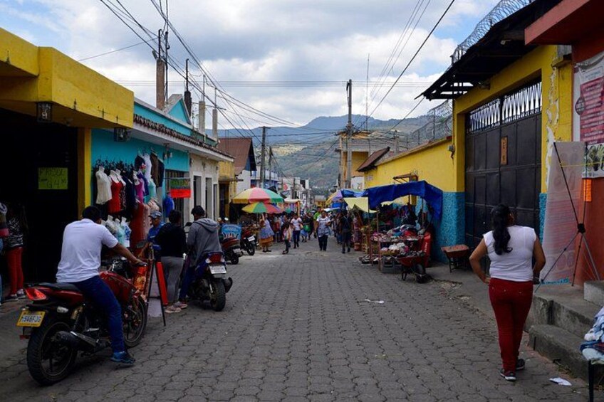 En livlig gata med affärer, motorcyklar och fotgängare. 2