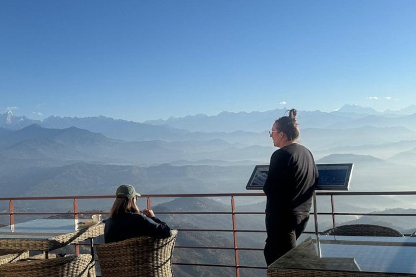 Two people overlooking a mountainous landscape from a viewing platform. 4