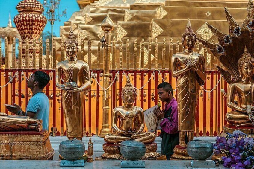 Golden statues of Buddha, a man reading a book, and a man holding a bowl. 3