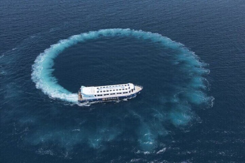 Ein großes Kreuzfahrtschiff hinterlässt eine kreisförmige Wasserwelle im Meer. 1