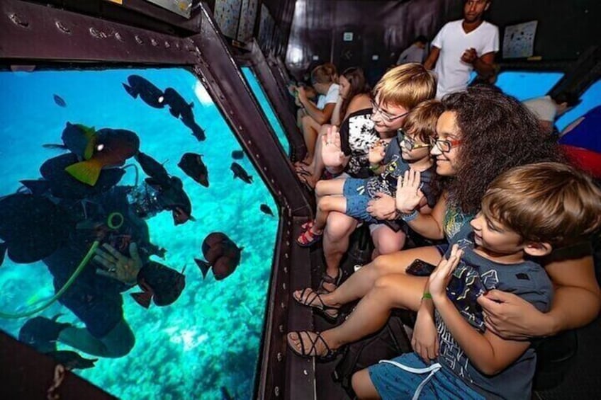 Ein Taucher in einer Unterwasserstation, Kinder beobachten durch eine Beobachtungskuppel. 2