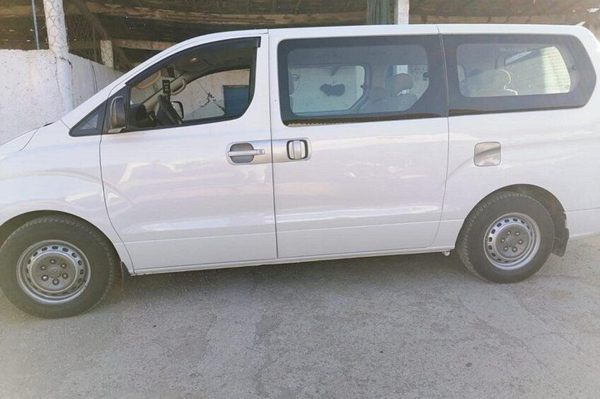 A white van parked on a concrete surface. 4