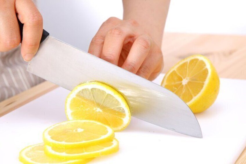 Una persona taglia un limone su un tagliere bianco. 5