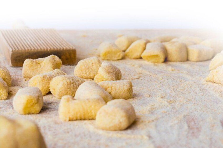 Panetti di pasta su una superficie infarinata, con un mattarello sullo sfondo. 2
