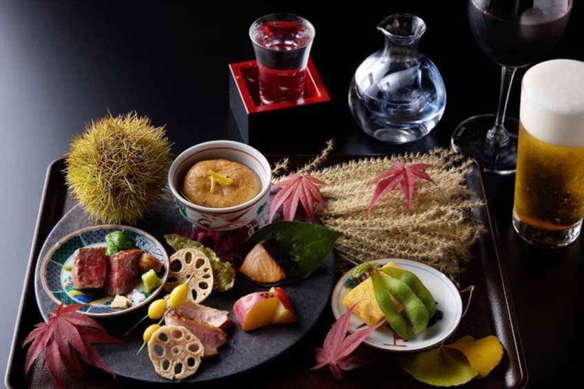 A tray with various food items, a bowl of soup, and a glass of beer. 2