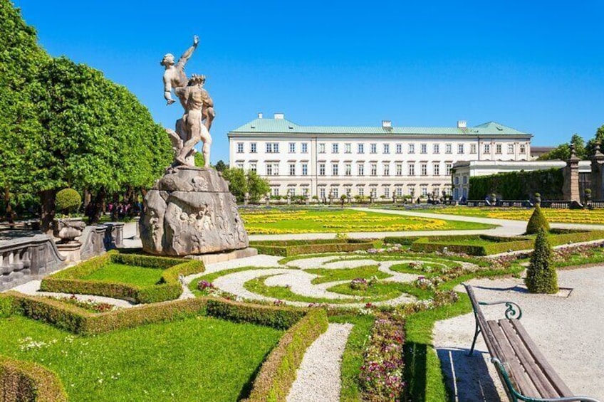Una statua in un giardino formale, con un grande edificio sullo sfondo. 1