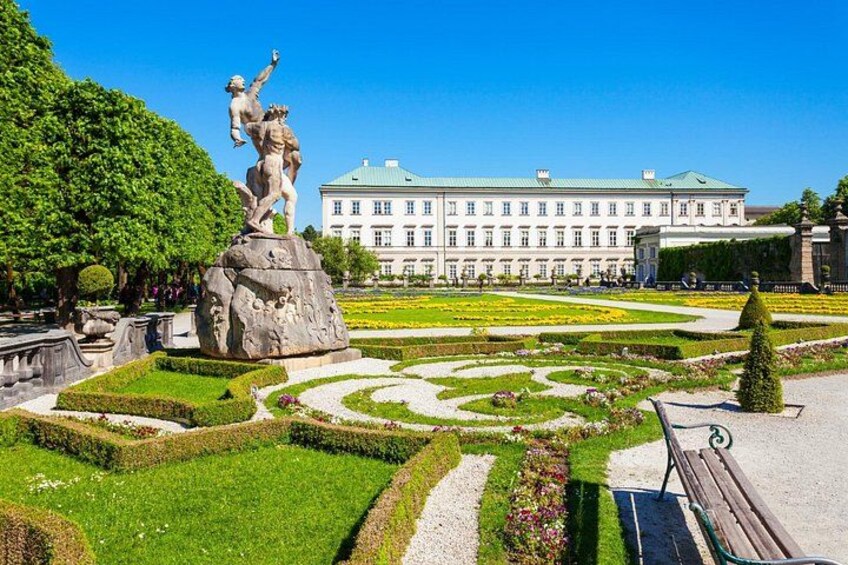 Una statua in un giardino formale, con un grande edificio sullo sfondo. 1