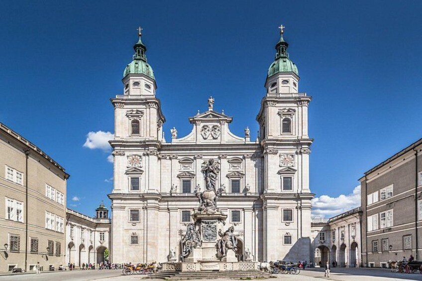 Un grande edificio storico con due torri, una statua centrale e una fontana di fronte. 5