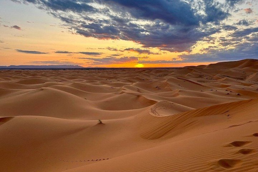 Woestijnlandschap met zandduinen en een ondergaande zon. 4