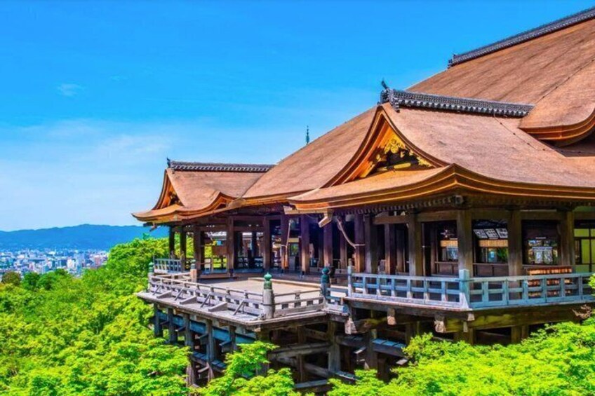 A traditional wooden building with a thatched roof, surrounded by lush greenery. 2