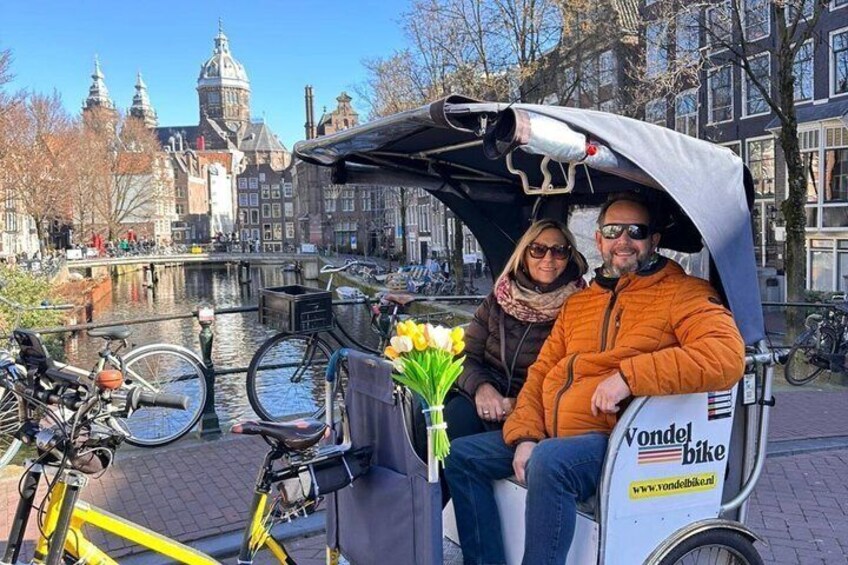 A canal with historic buildings, a yellow bicycle, and a Vondel bike rental service. 4