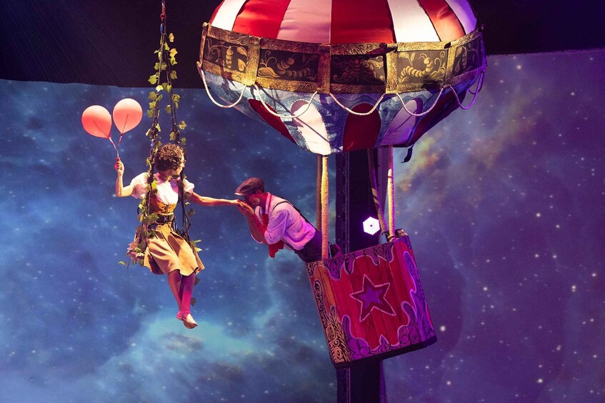 A person on a swing with a hot air balloon. 4