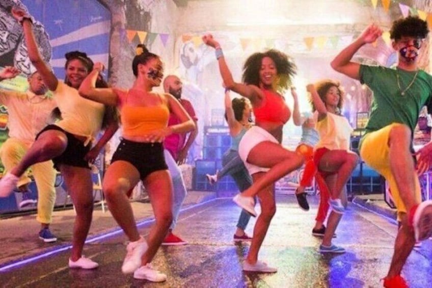 A group of people dancing in a brightly lit indoor space with colorful decorations and graffiti on the walls. 4