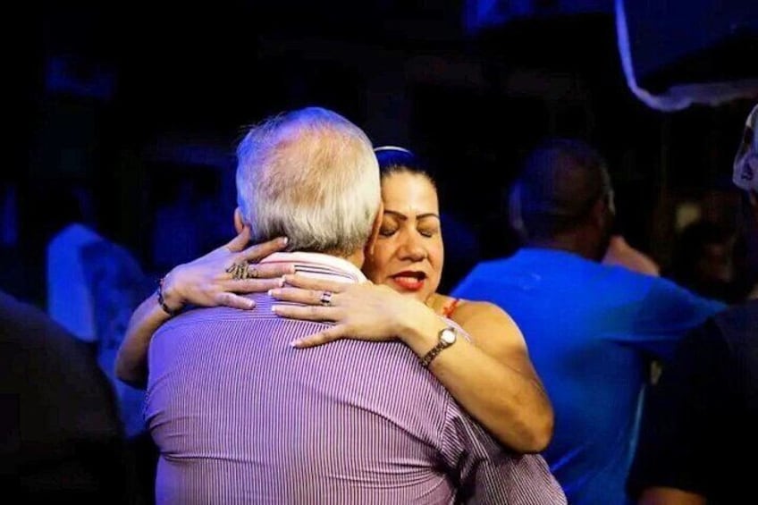 A person embracing another person in a crowded setting. 1