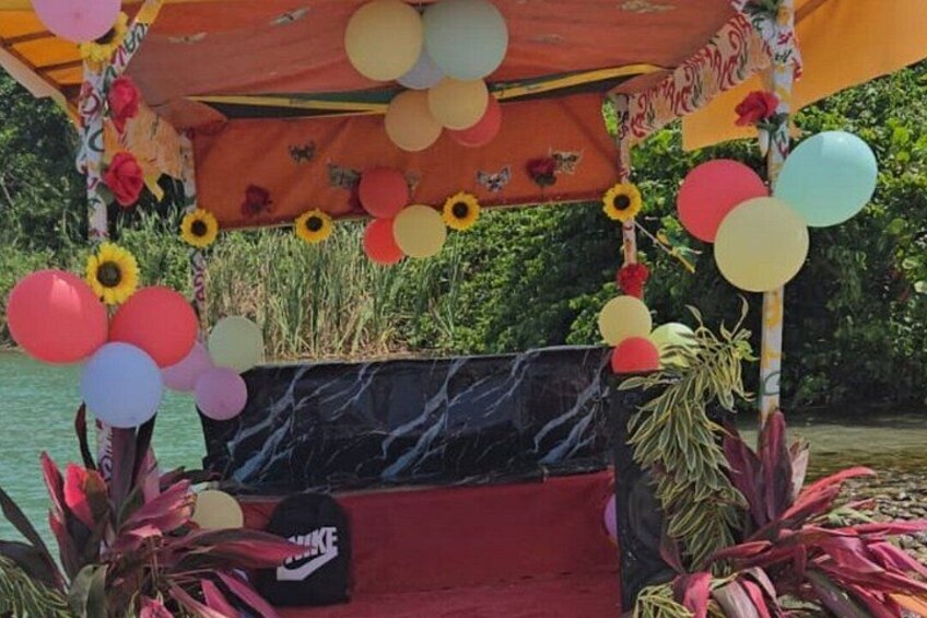 Un espace extérieur aménagé avec des sièges, agrémenté d’un banc et entouré de ballons et de plantes. 3