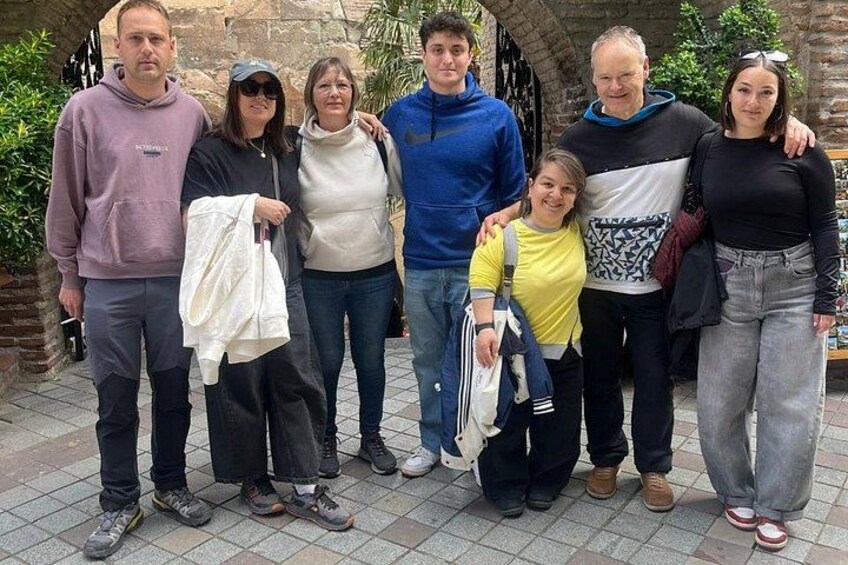 Un grupo de personas al aire libre sobre una superficie de baldosas, algunas sosteniendo objetos. 5