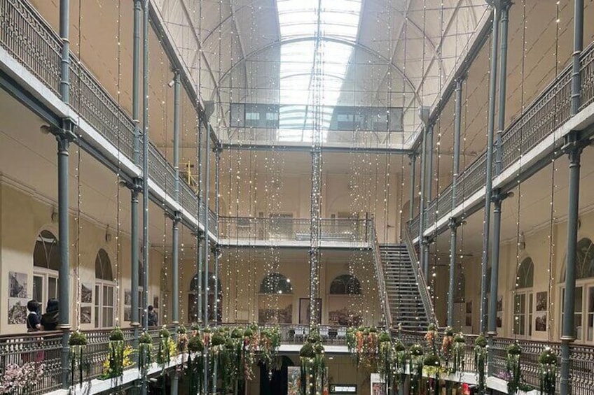 A spacious indoor atrium with a high ceiling, multiple balconies, and a central staircase. 3