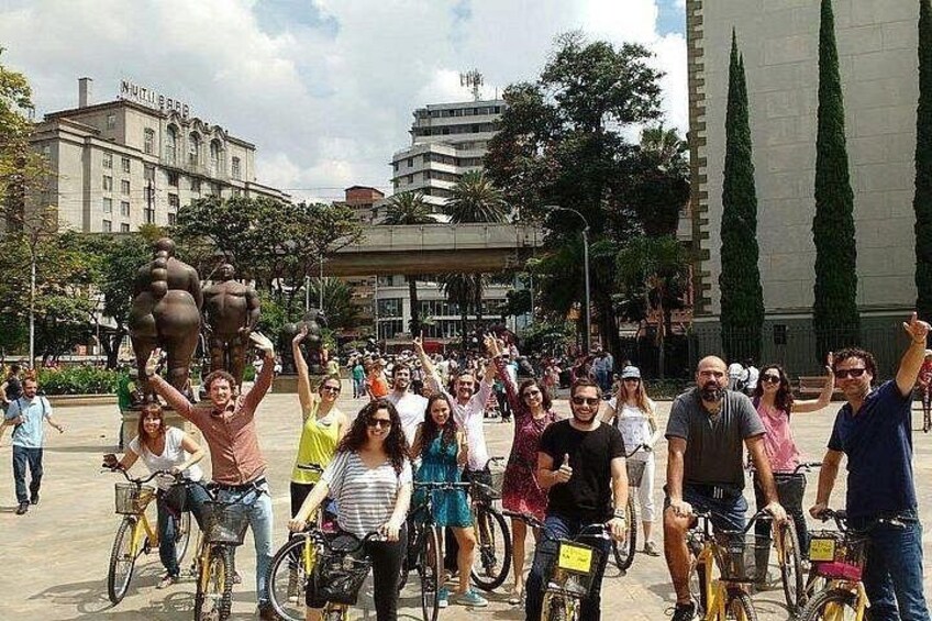 Eine Gruppe von Radfahrern in einer städtischen Umgebung, im Hintergrund Gebäude und Bäume. 2
