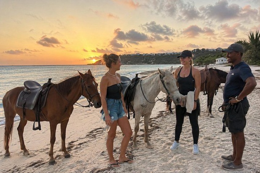 A beach with horses and people. 5