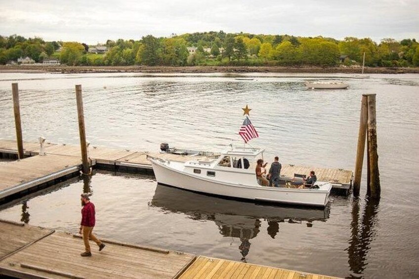 A boat docked at a wooden pier with a person walking on the pier. 4
