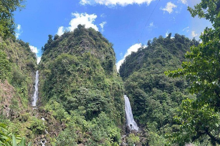 A waterfall cascading down a lush, green mountain. 2