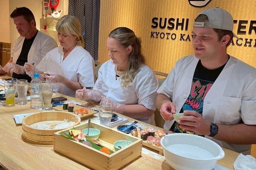 En sushibar med träbord, skålar och ätpinnar. 4