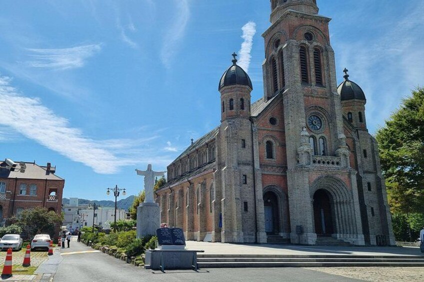 A large brick church with two domes and a tall bell tower. 3