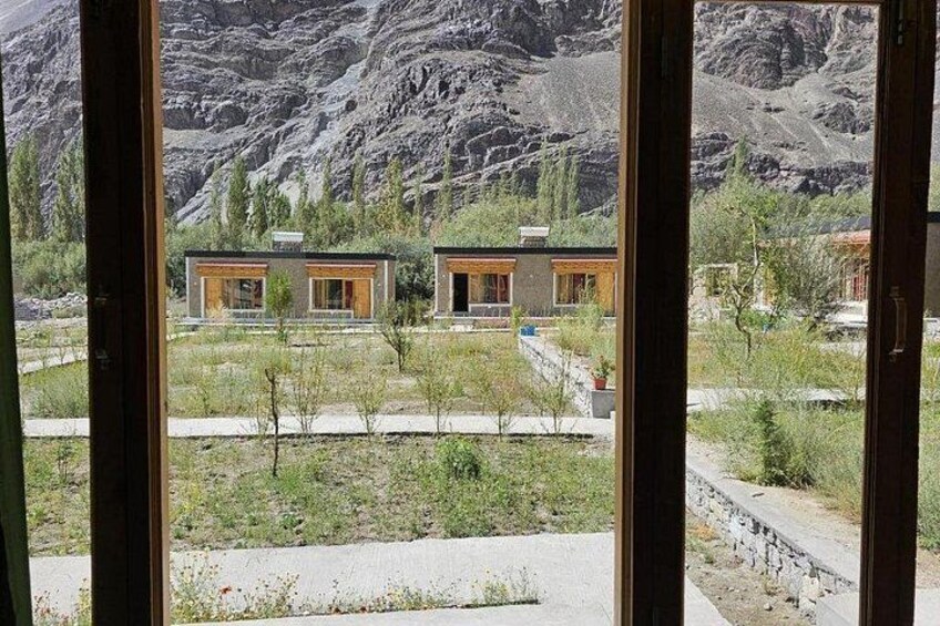 A mountainous landscape with two modern houses and a clear sky. 5