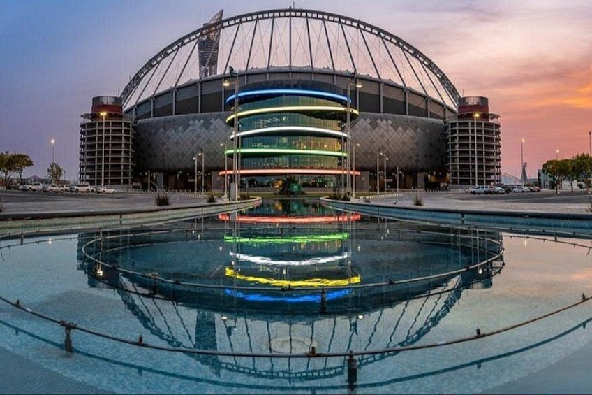 A stadium with a large circular pool in front. 1