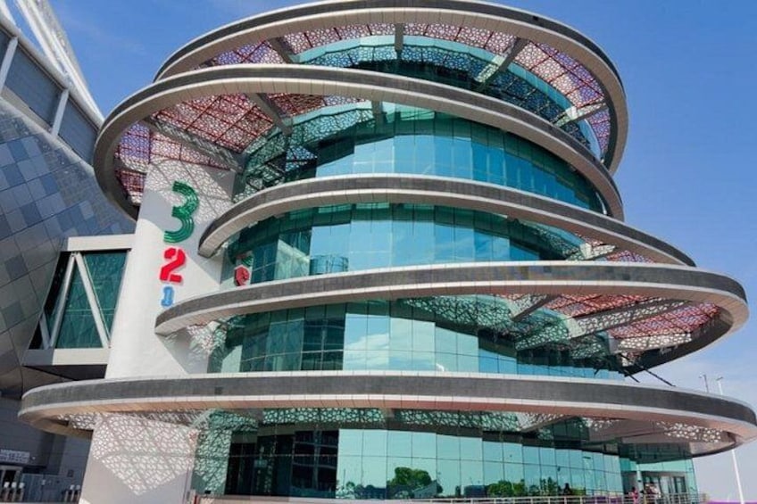 A modern building with a circular design, featuring multiple glass windows and a prominent number '322' on its facade. 5