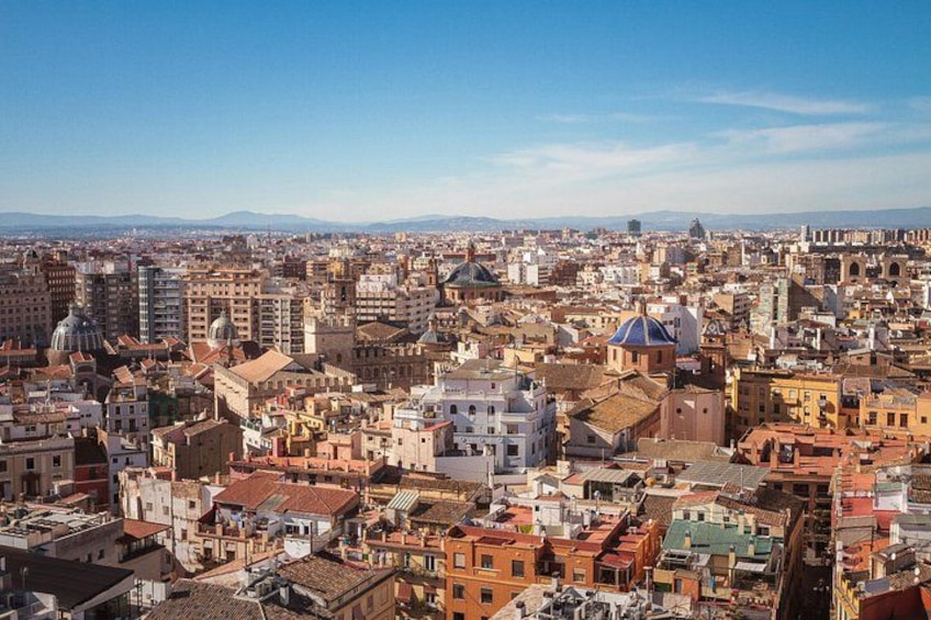 A densely packed urban landscape with a variety of building styles and colors, including domed structures and flat-roofed buildings. 5