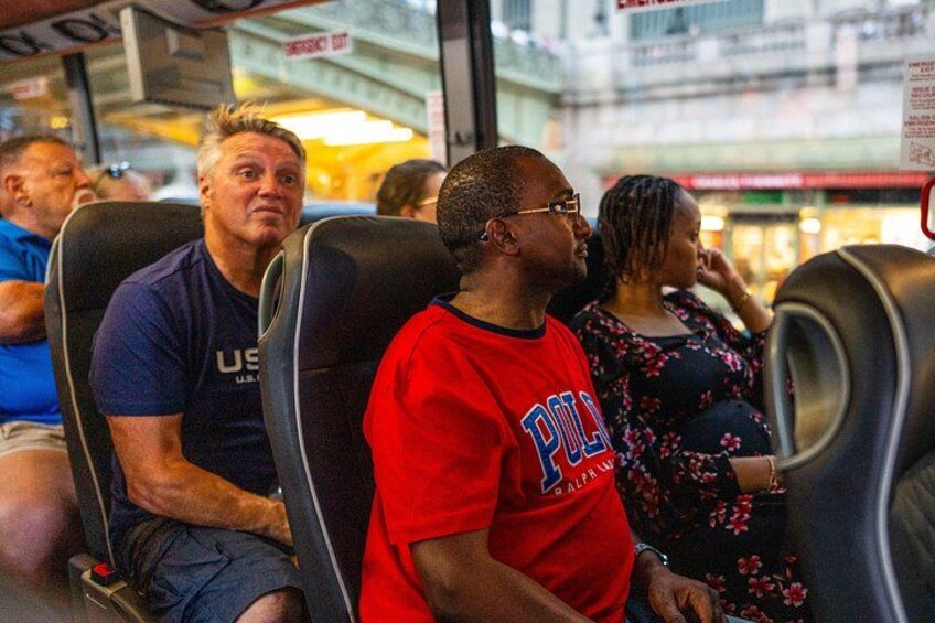 Des passagers sont assis dans un autobus, et certains portent des t-shirts à l’effigie d’équipes sportives. 4