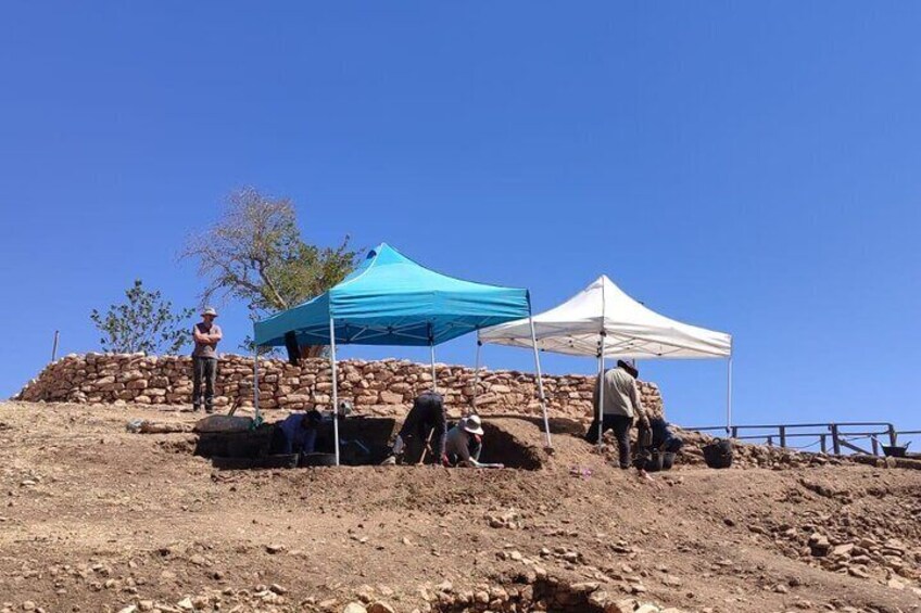 A group of people on a rocky hill with tents. 3