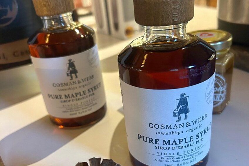 Dos botellas de sirope de arce puro Cosman & Webb sobre una mesa. 3