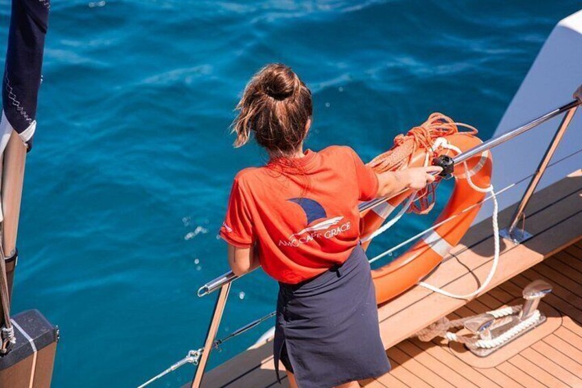 Eine Person in einem roten Hemd auf einem Boot, die eine Rettungsboje hält. 5