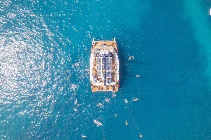 Un barco anclado en aguas azules y transparentes, con algunas embarcaciones más cerca. 5