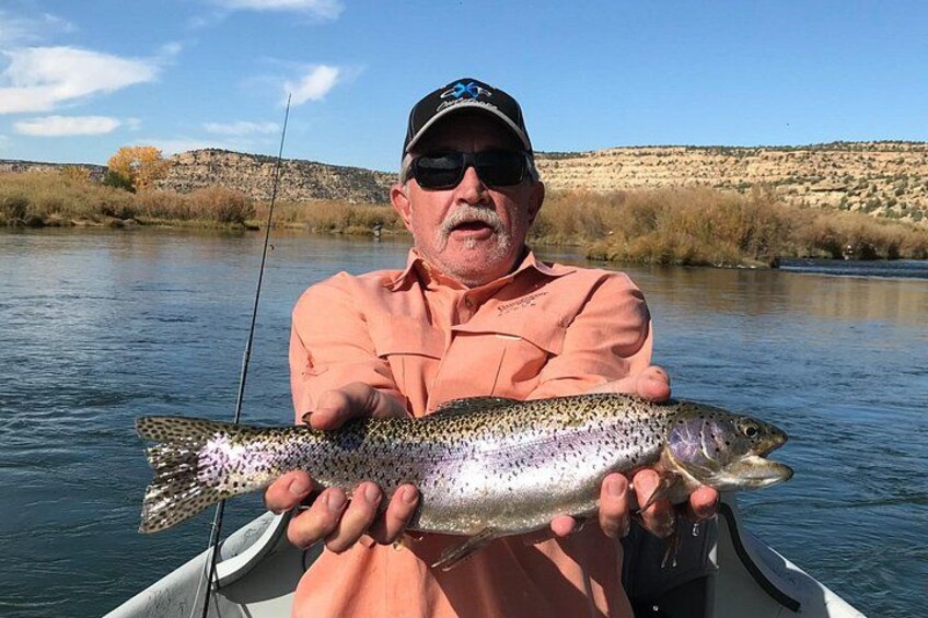A man in a boat holding a fish. 2