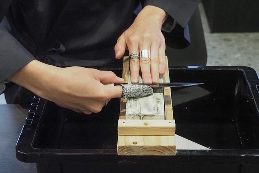 Una persona che usa un coltello per tagliare un pezzo di carta. 1