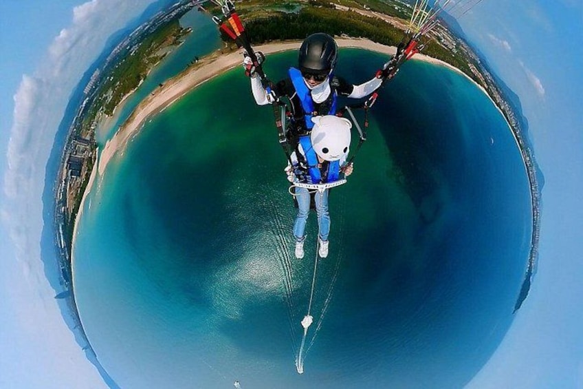 A person paragliding over a large body of water with a clear sky. 5