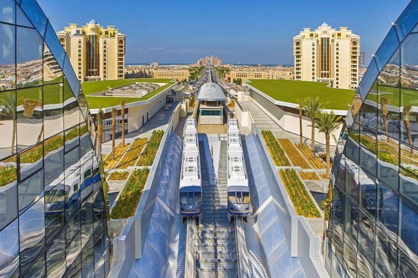 Une gare moderne avec deux trains, des bâtiments en verre et des immeubles de grande hauteur qui l’entourent. 3