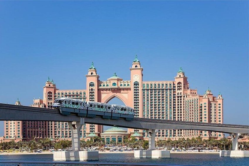 Un train sur un pont, avec un grand bâtiment d’hôtel en arrière-plan. 2