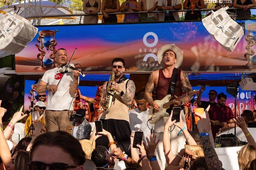 Een live band treedt op, met een publiek op de achtergrond. 5