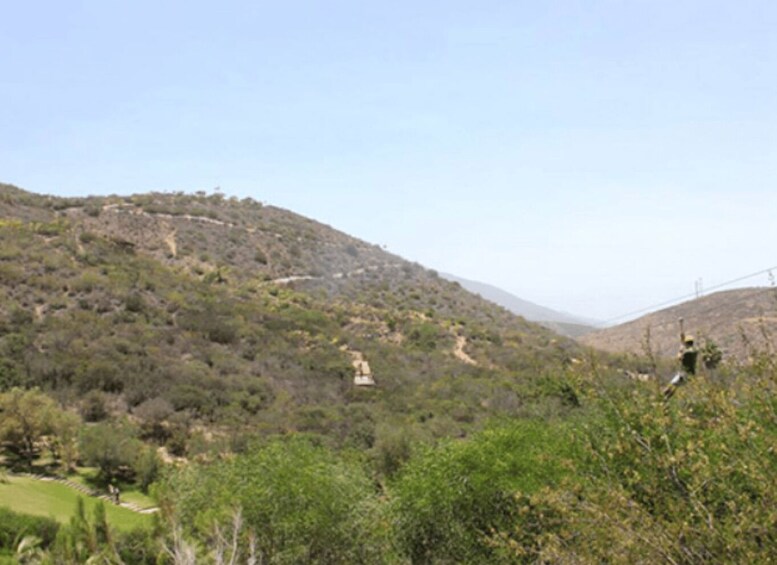A hilly landscape with sparse vegetation and a clear sky. 3