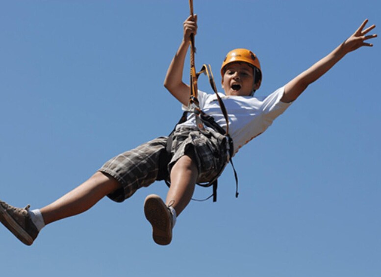 A person ziplining with a helmet and harness. 4