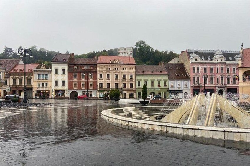 A historic square with a fountain, surrounded by colorful buildings. 3