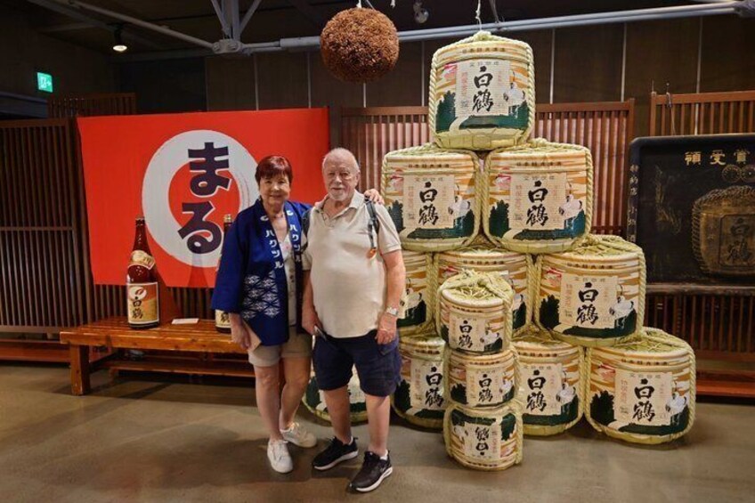 Dos personas frente a una exhibición de contenedores apilados con texto en japonés. 1