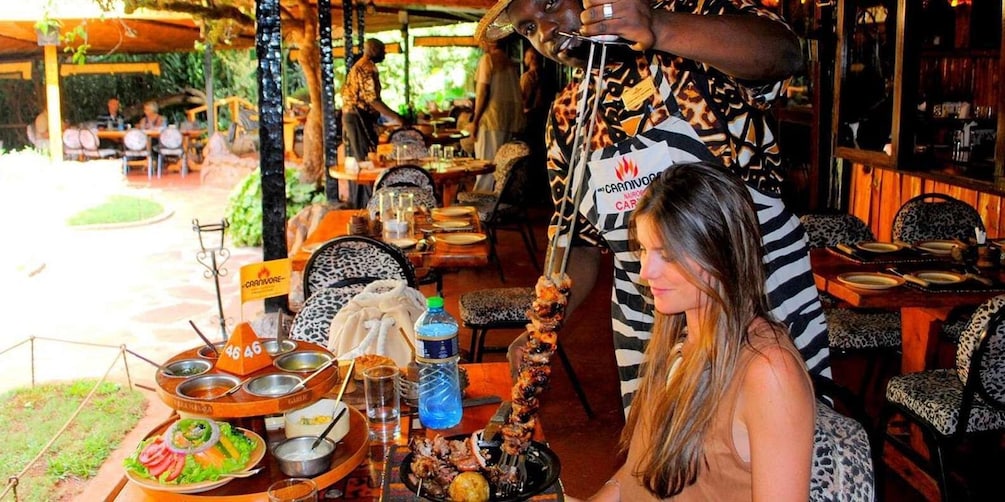 Un ristorante con posti a sedere all'aperto, uno spiedino di cibo e un cartello con scritto Carnivore. 5