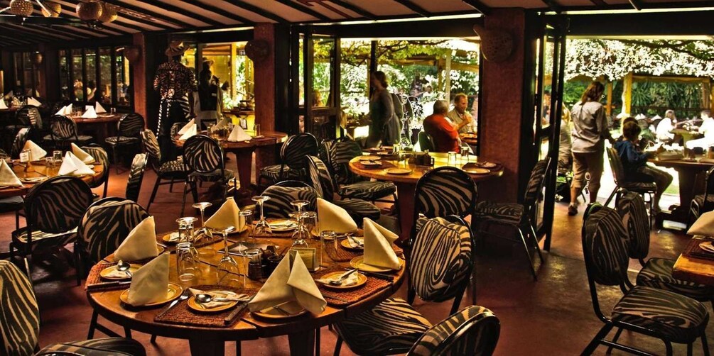 Un ristorante con sedie e tavoli a righe zebrate, apparecchiati per la cena. 4