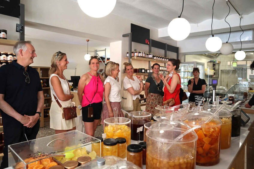 A group of people in a food store with various food items on display. 1