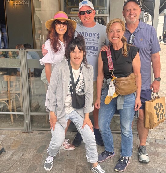 A group of people standing in front of a building with a glass door. 4